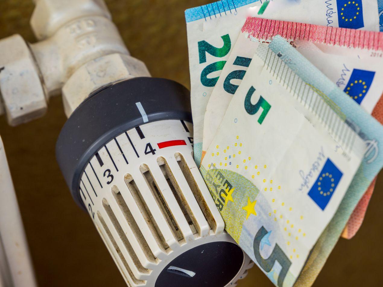 Nahaufnahme eines Heizungsthermostats mit Euro-Geldscheinen – steigende Heizölpreise Sachsen und höhere Energiekosten im Haushalt